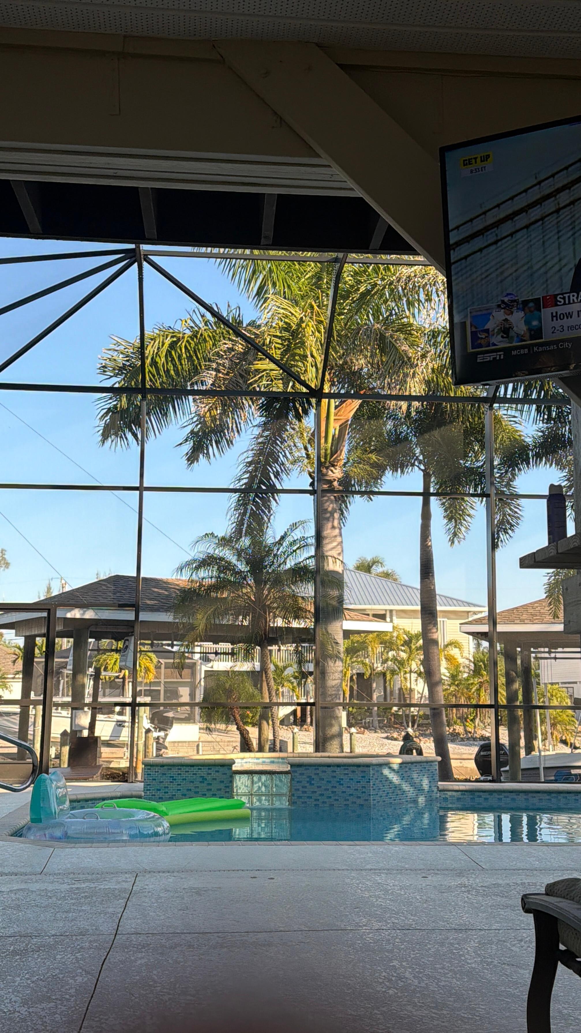 The outdoor TV with the pool behind it. 