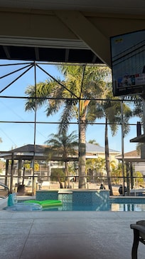 The outdoor TV with the pool behind it.