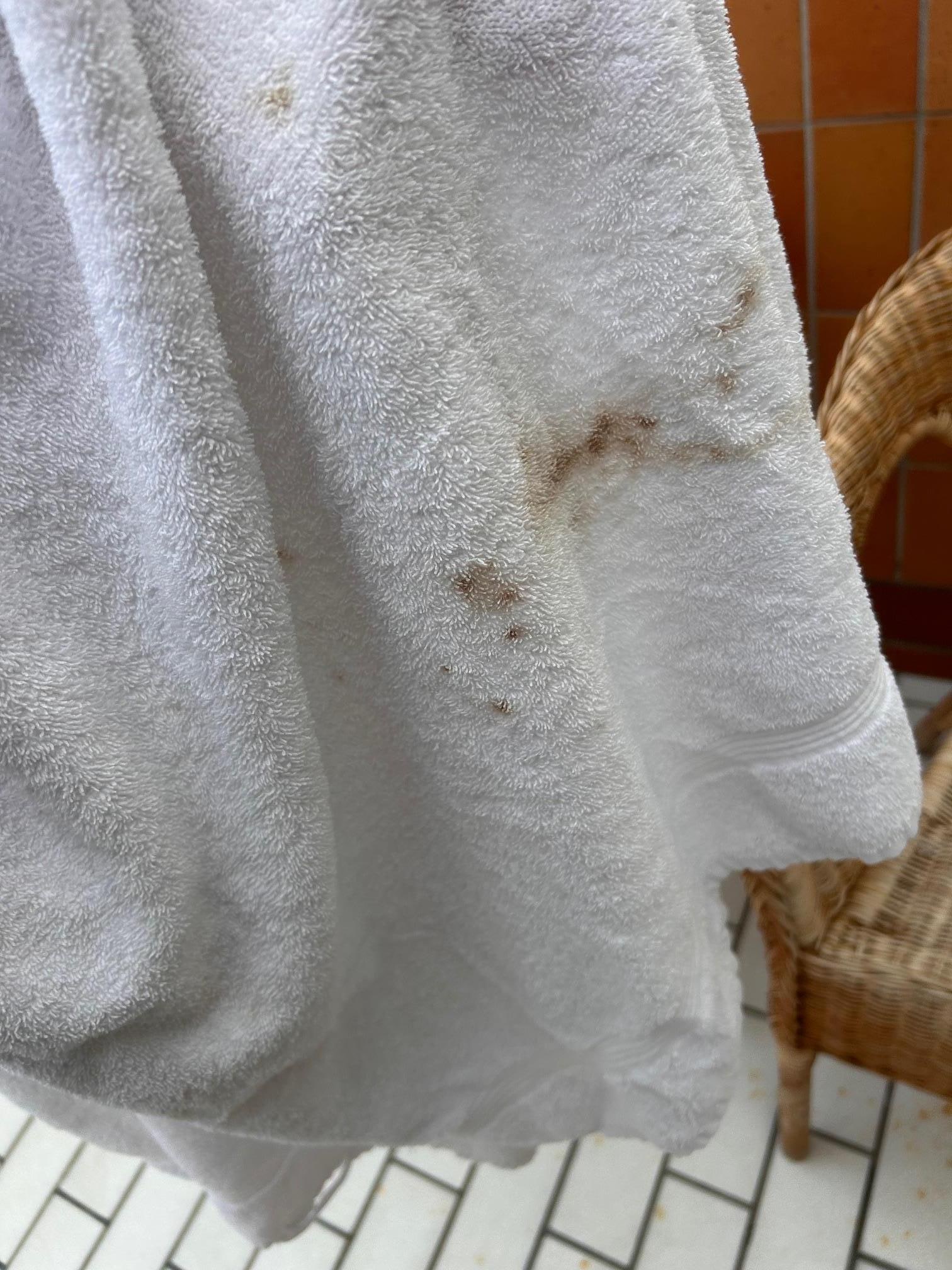 Bruna smutsfläckar på handduken från hotellrummet.