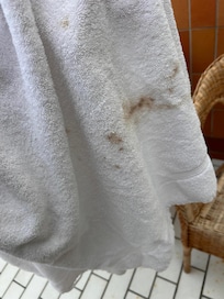 Bruna smutsfläckar på handduken från hotellrummet.