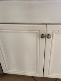 extremely dirty kitchen cabinet around top and pulls