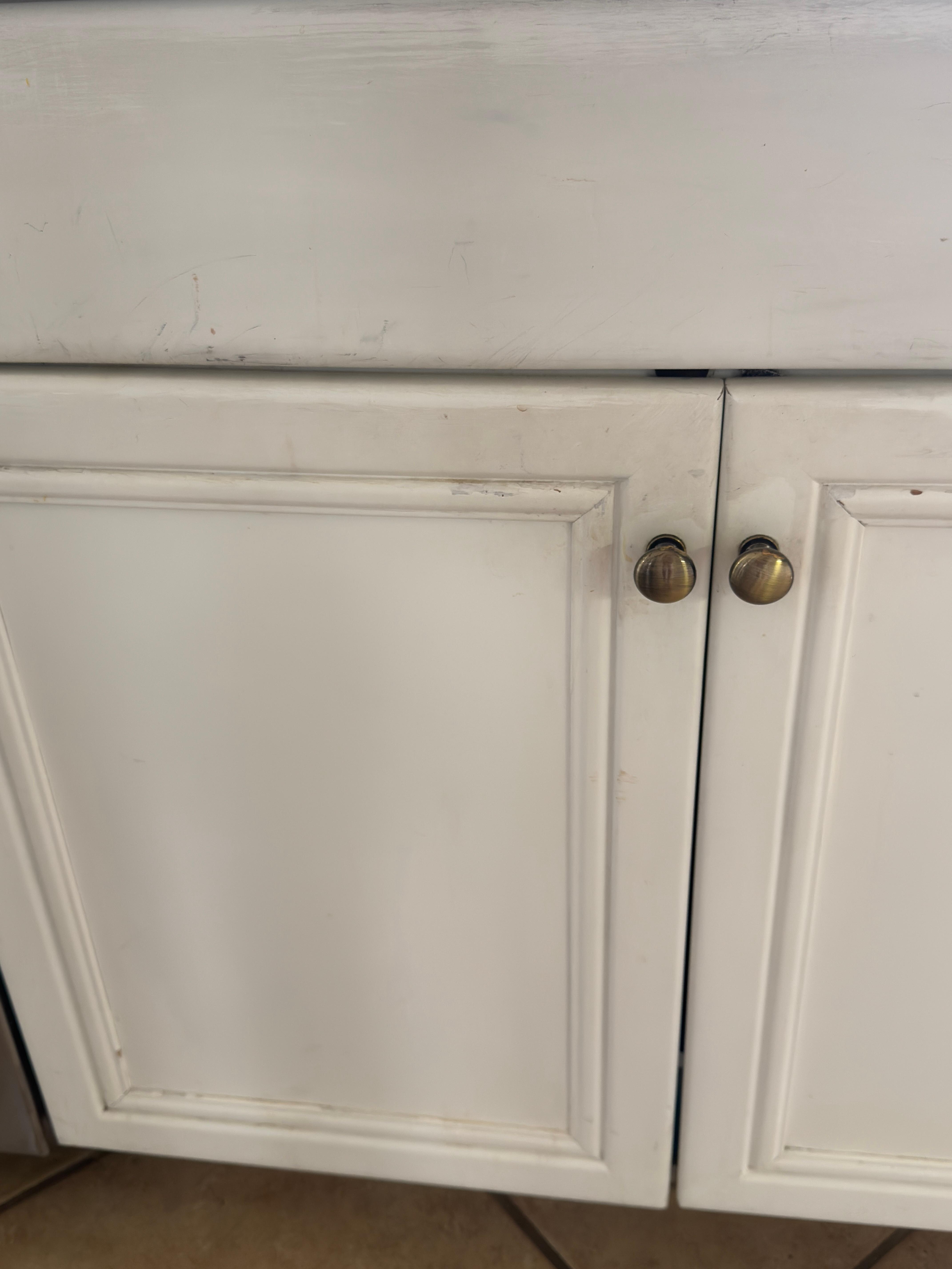 extremely dirty kitchen cabinet around top and pulls
