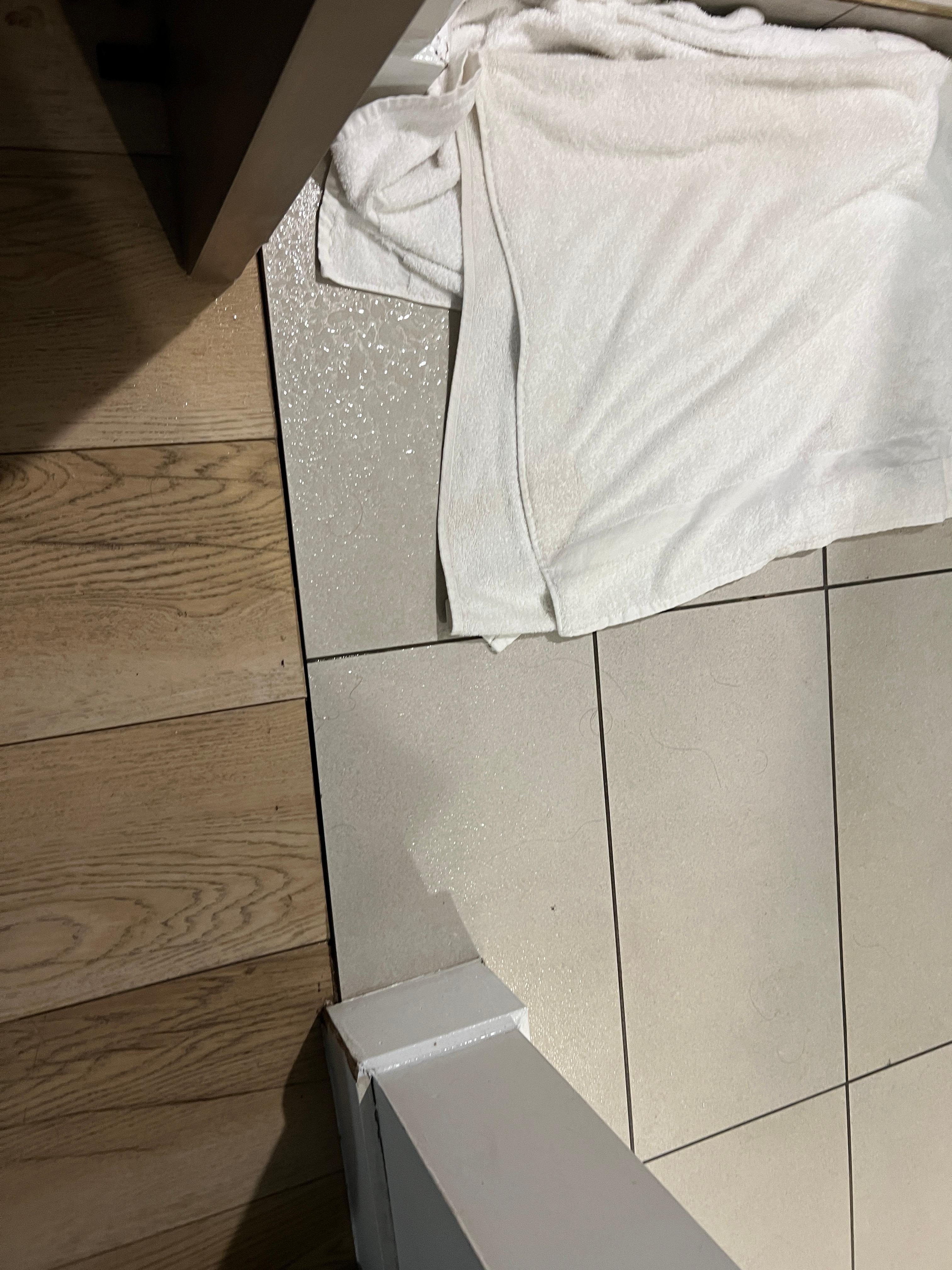 Flooring at shower stall gets wet outside shower due to half glass divider and wrong big shower head at bedroom area.