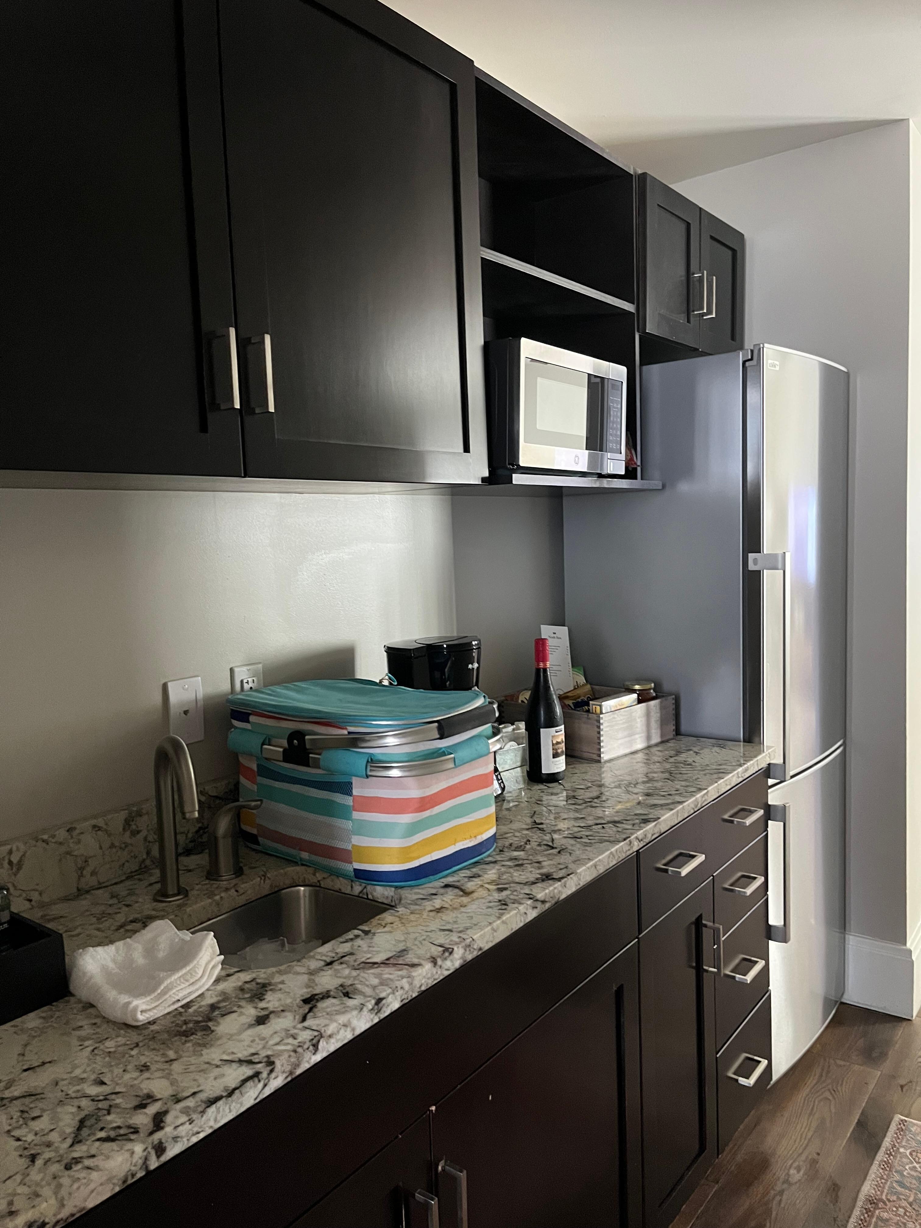 Full gallery kitchen, with glasses, silverware, plates and bowls.  Microwave and full size coffee maker. 
