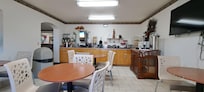 Dining area with plenty of breakfast options: dry cereal, waffles, bread, English muffin and regular muffin, orange juice and apple juice.
