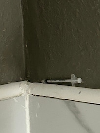 Syringe in wall by shower