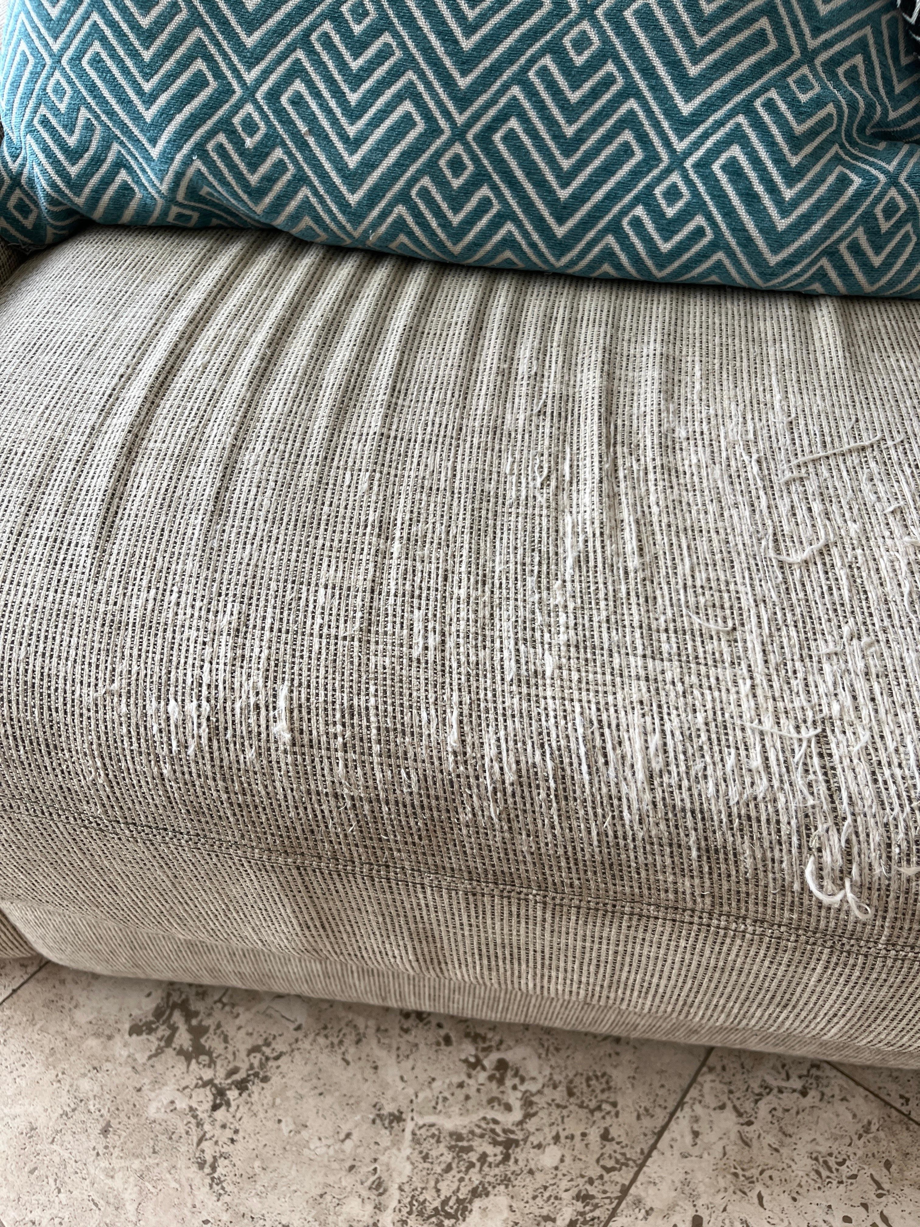 couch that appears to have been used as scratching post by a cat