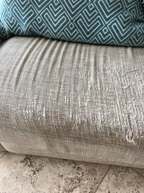 couch that appears to have been used as scratching post by a cat