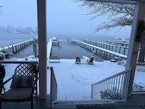 View of the water past the snow covered deck
