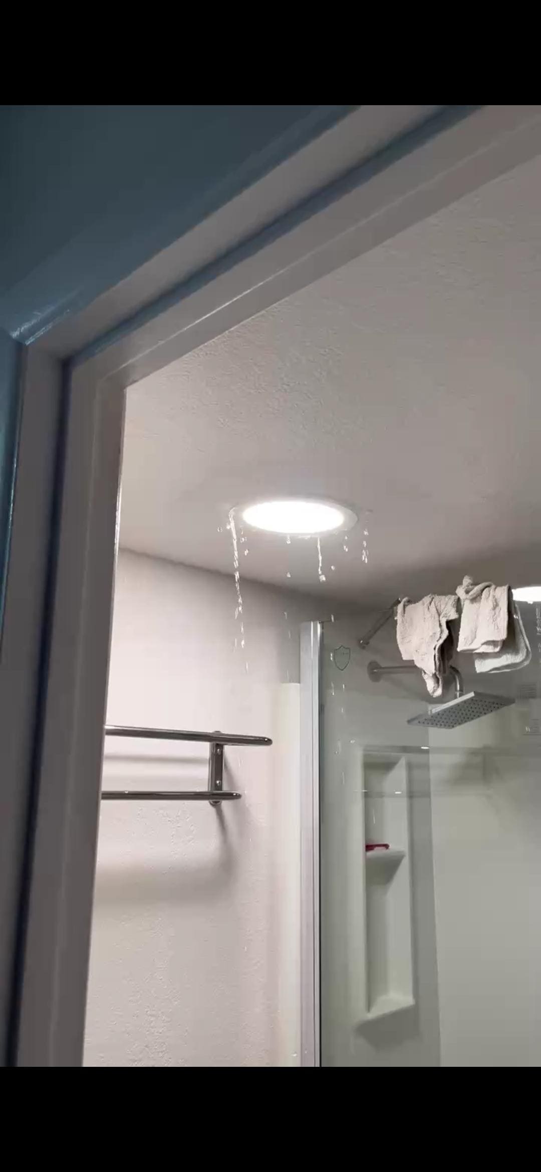 Water pouring from ceiling through light fixture 