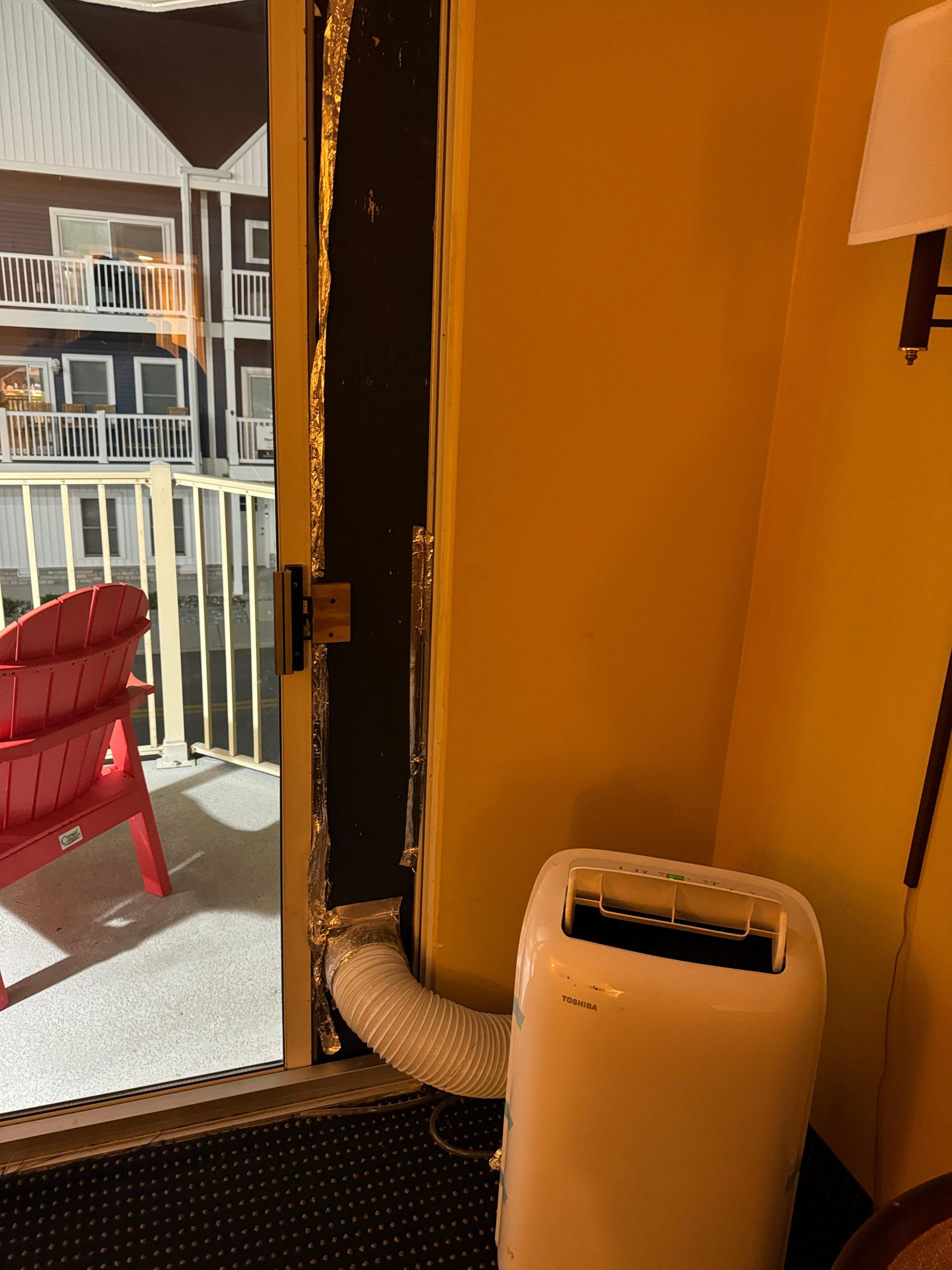 Unsecured plywood in patio door to rig the portable AC unit