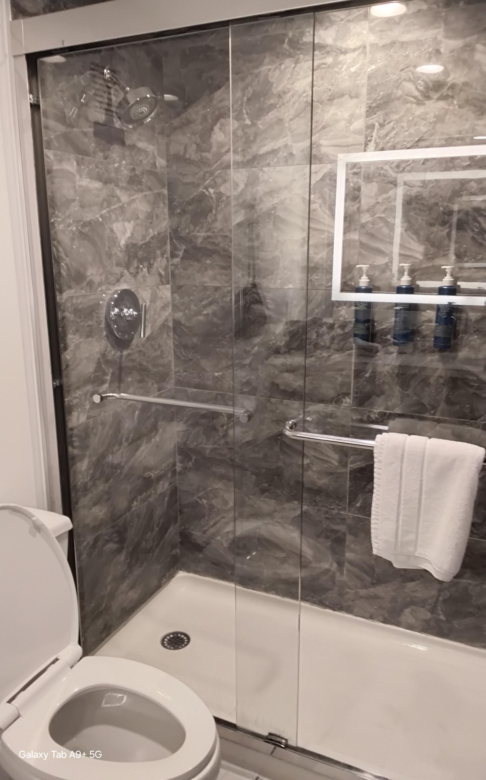 Marble backsplash & flooring, backlit wall mirrors, stylish decor