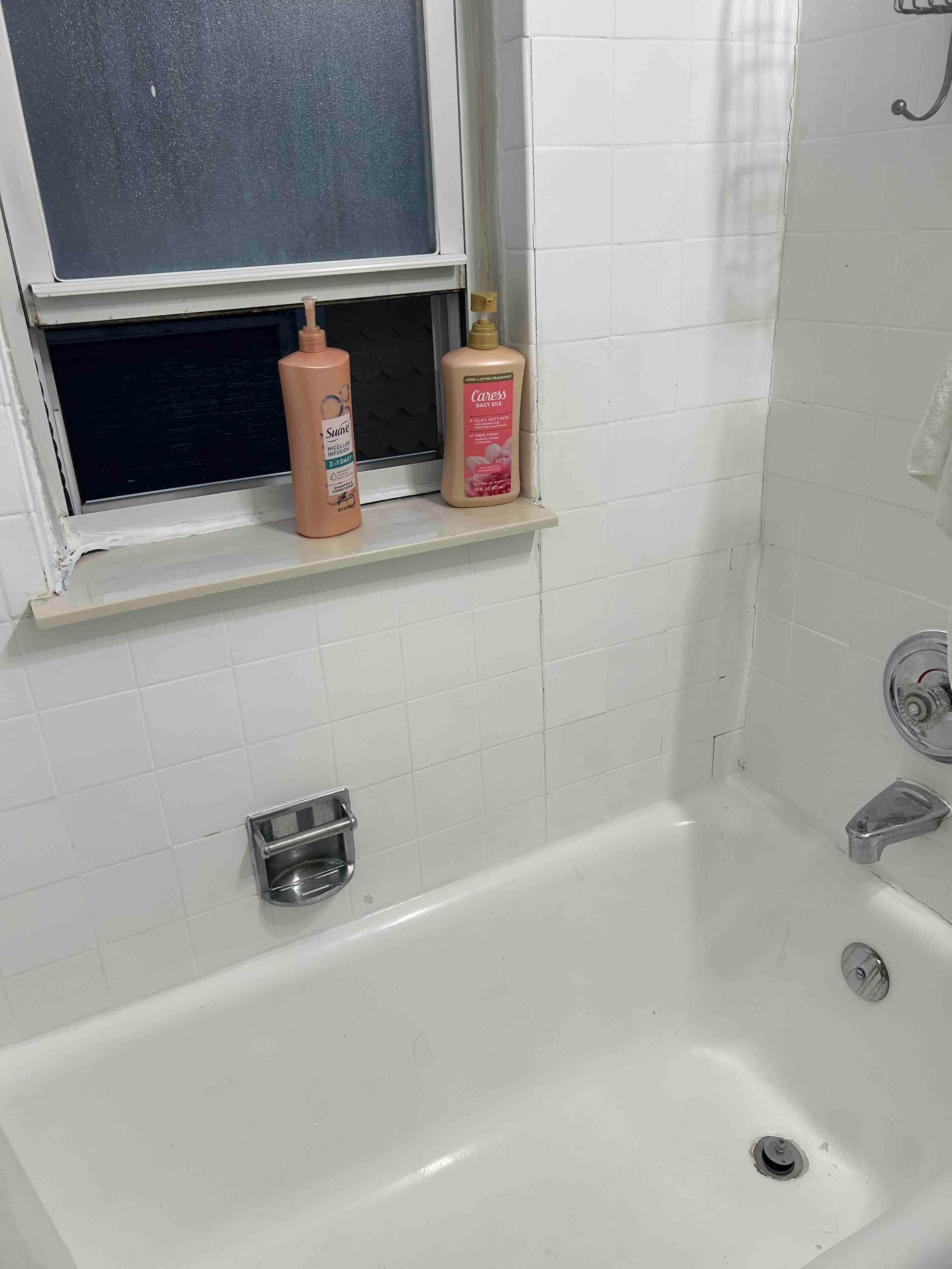 State of bathroom. Chips in Tub, and peeling paint on window sill 