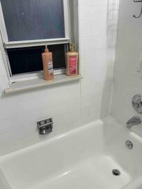 State of bathroom. Chips in Tub, and peeling paint on window sill