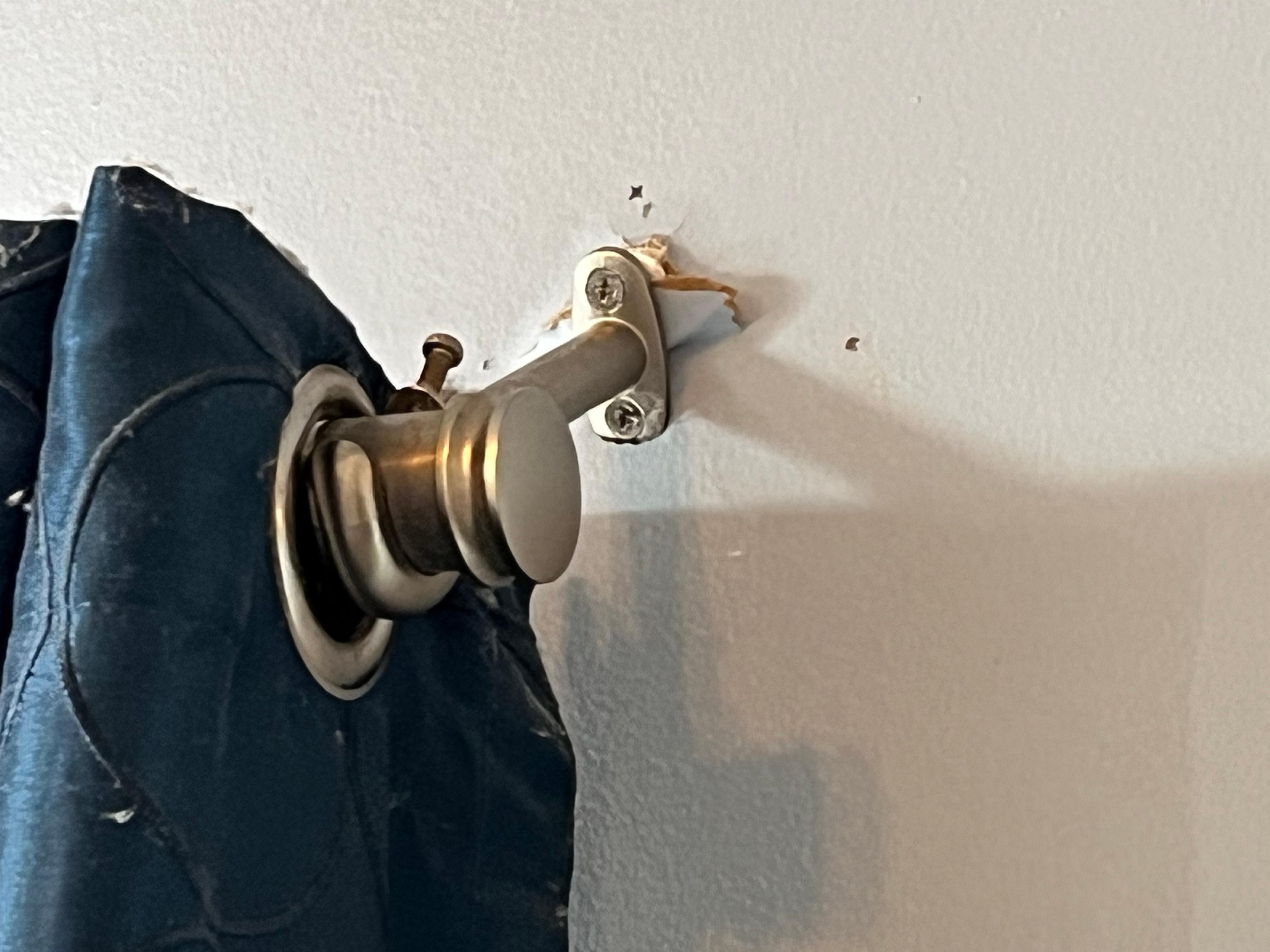 Curtain rod in living room coming out of the wall.