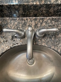 Dirty sink with a half of a pill on the counter