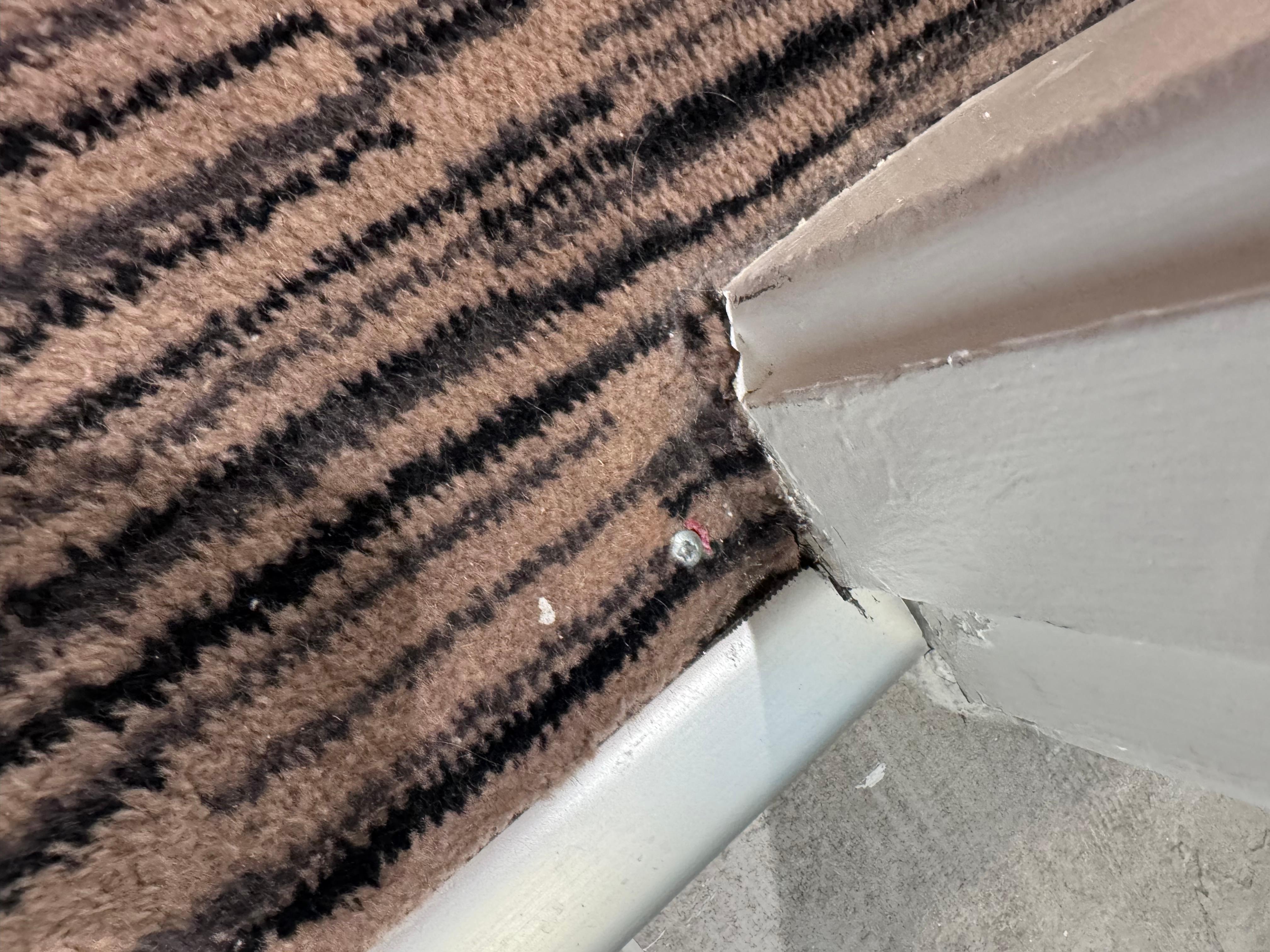 Carpet didn’t go all the way over carpet strip in many locations. They gave up and screwed it in place