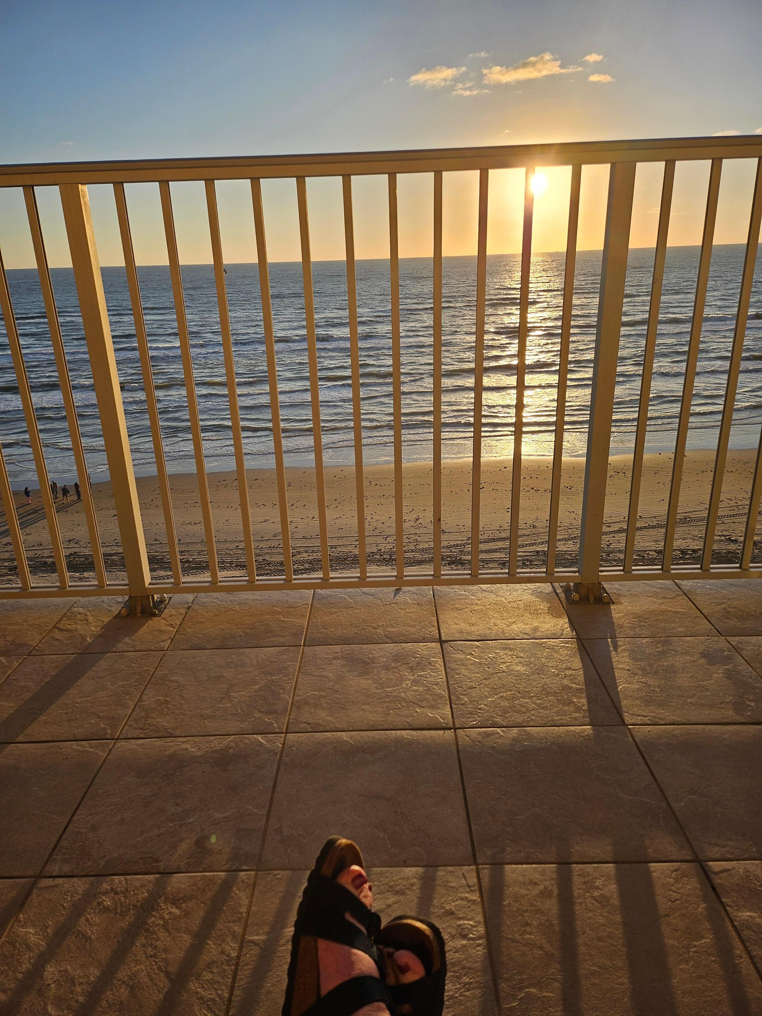 Enjoying coffee from a patio chair.