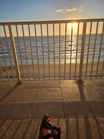 Enjoying coffee from a patio chair.
