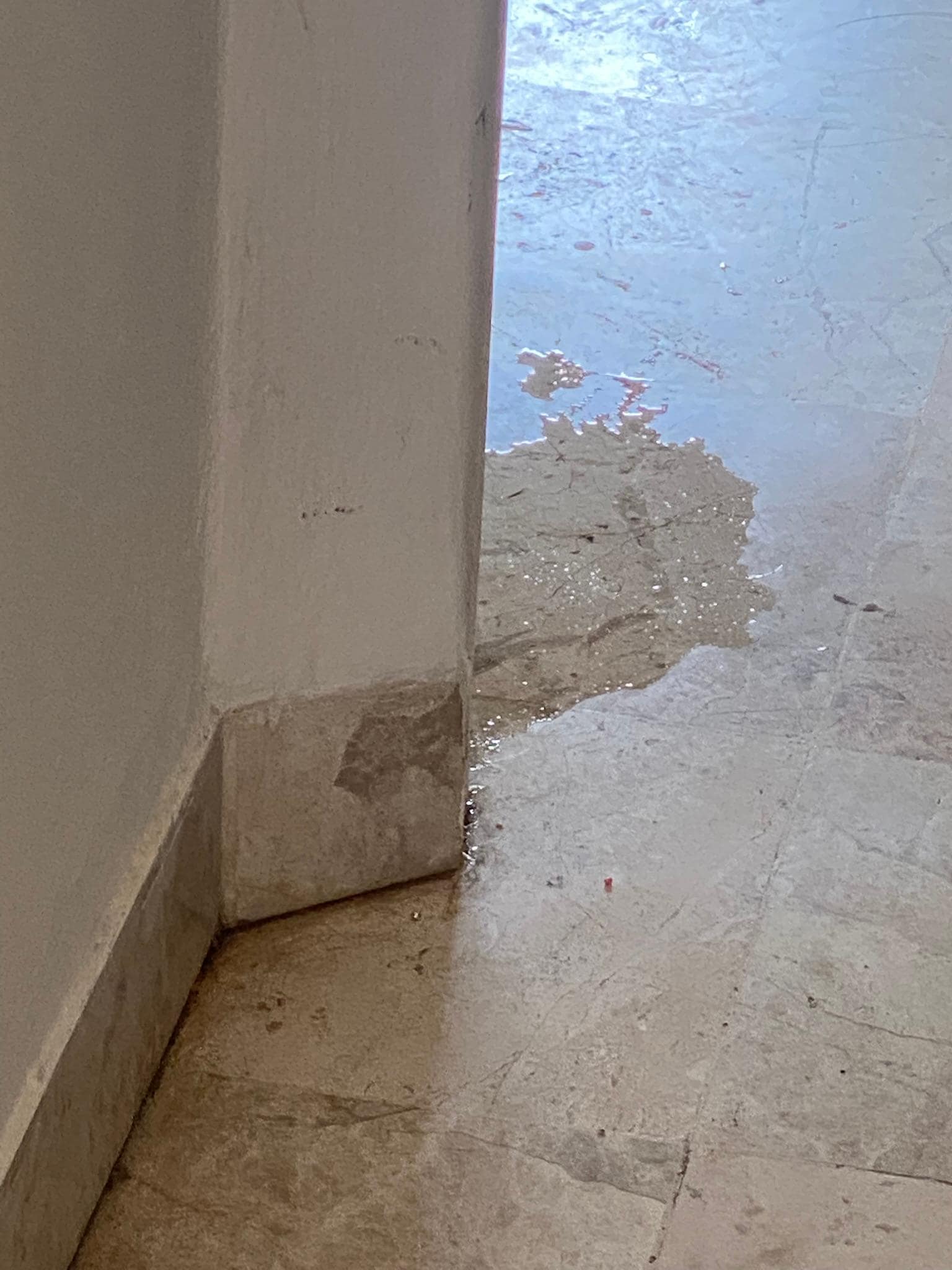 Beginning of leak from wall onto the floor.  It grew in size every day.