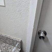 Yellow dried on liquid splatter on wall beside sink.