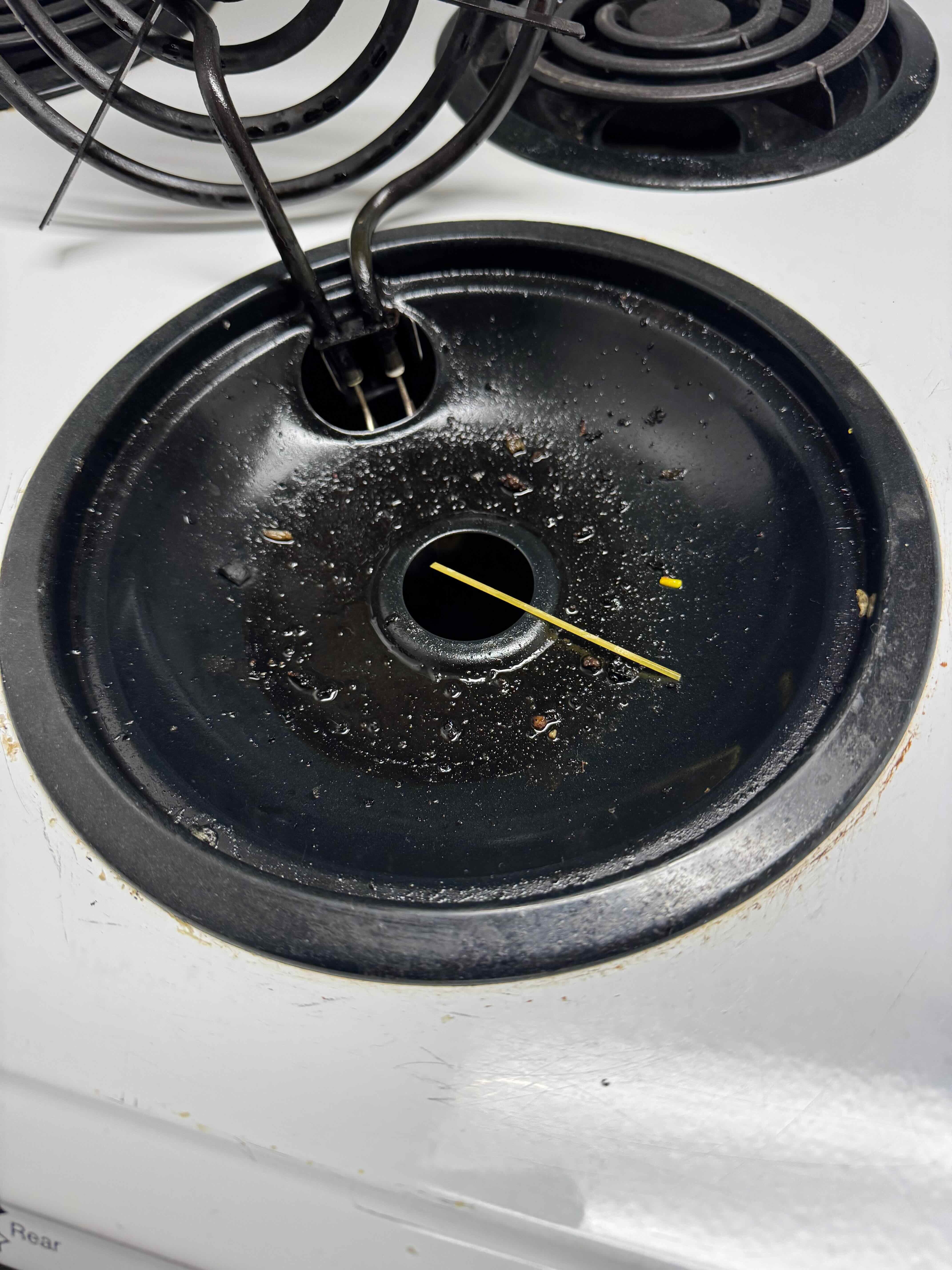 Stoves not clean.  Oil pooled in the pan in addition to a stick sitting in the pan along with other debris