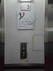 The wall next to the elevator on the third floor. Dirty, old, in need of care.