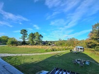 View of the firepit from the deck of Dome 1 with airstream rental in background