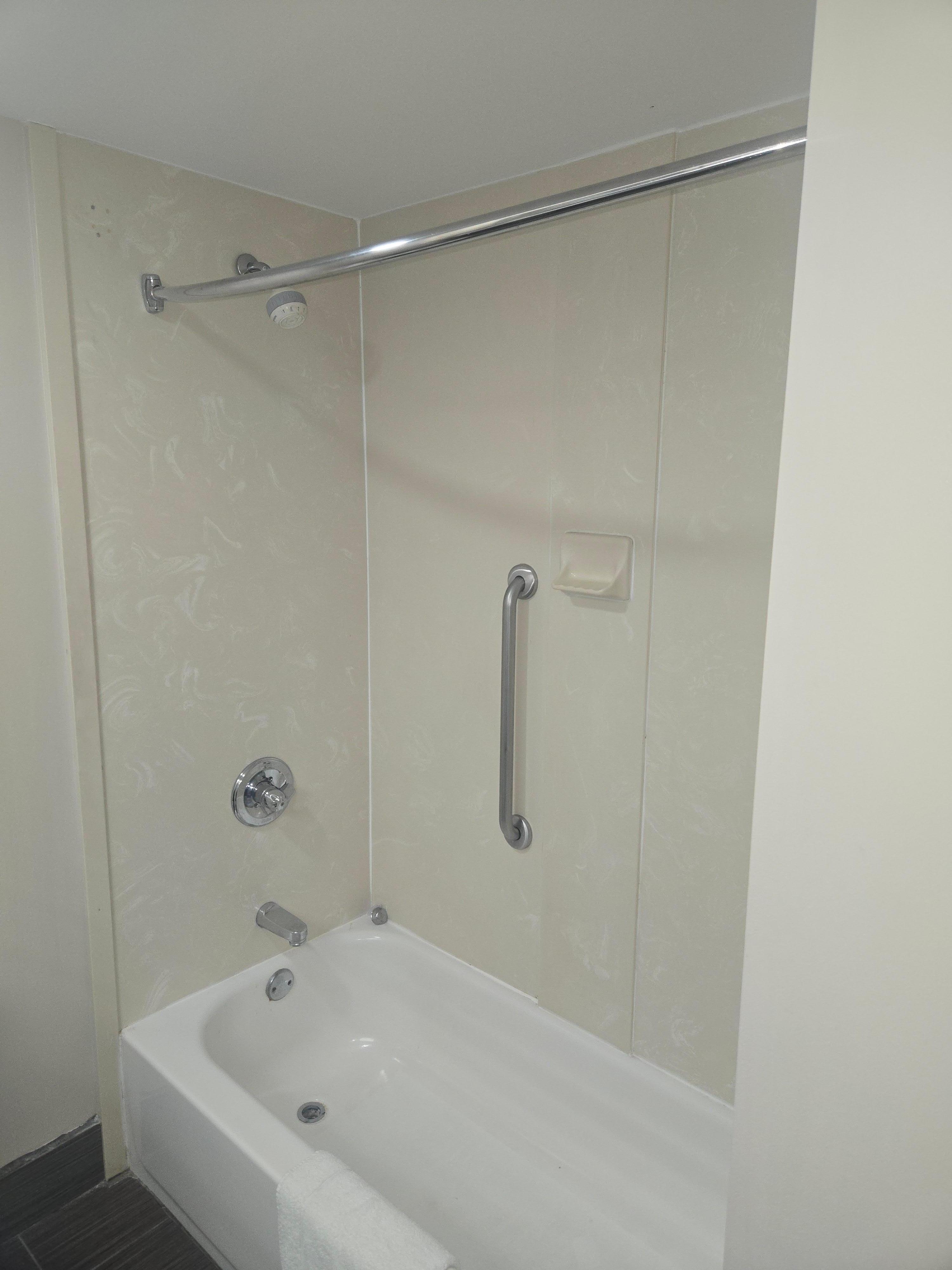 No shower curtain, and mold around the bottom of the wall against the tub.