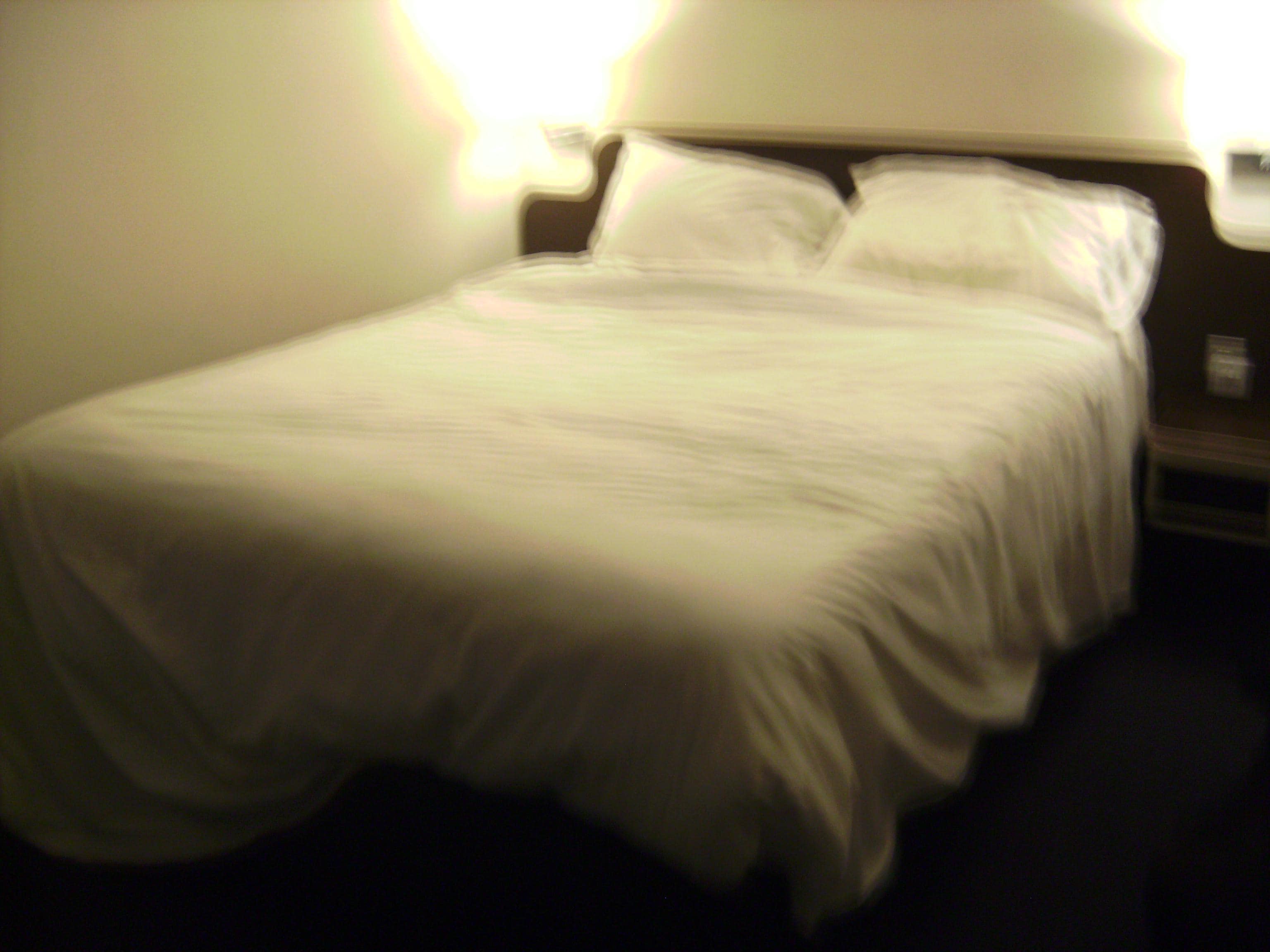 A comfy double bed with two bedside lamps.