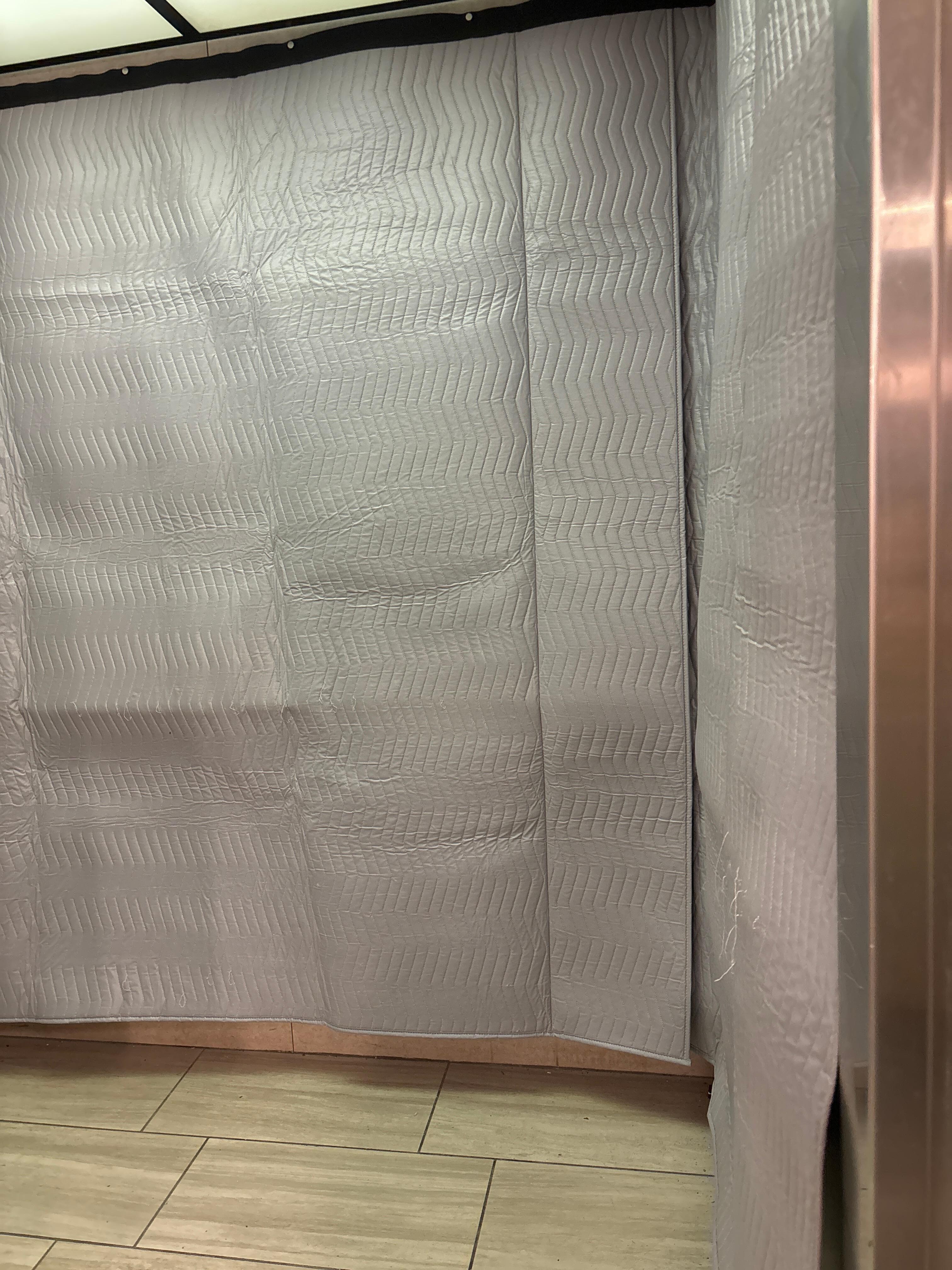 Elevator with moving quilt wallls
