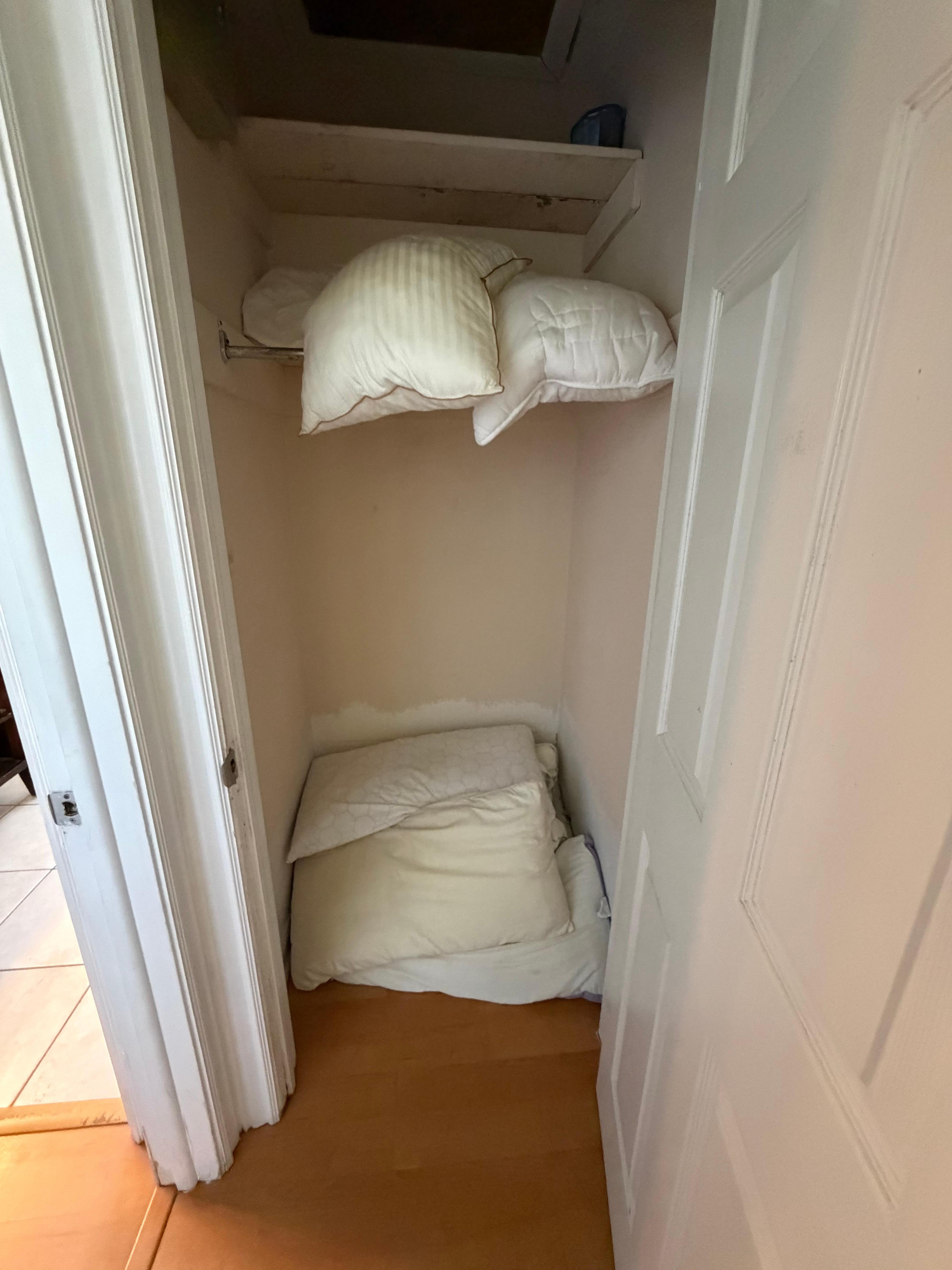 Spare pillows on floor in closet