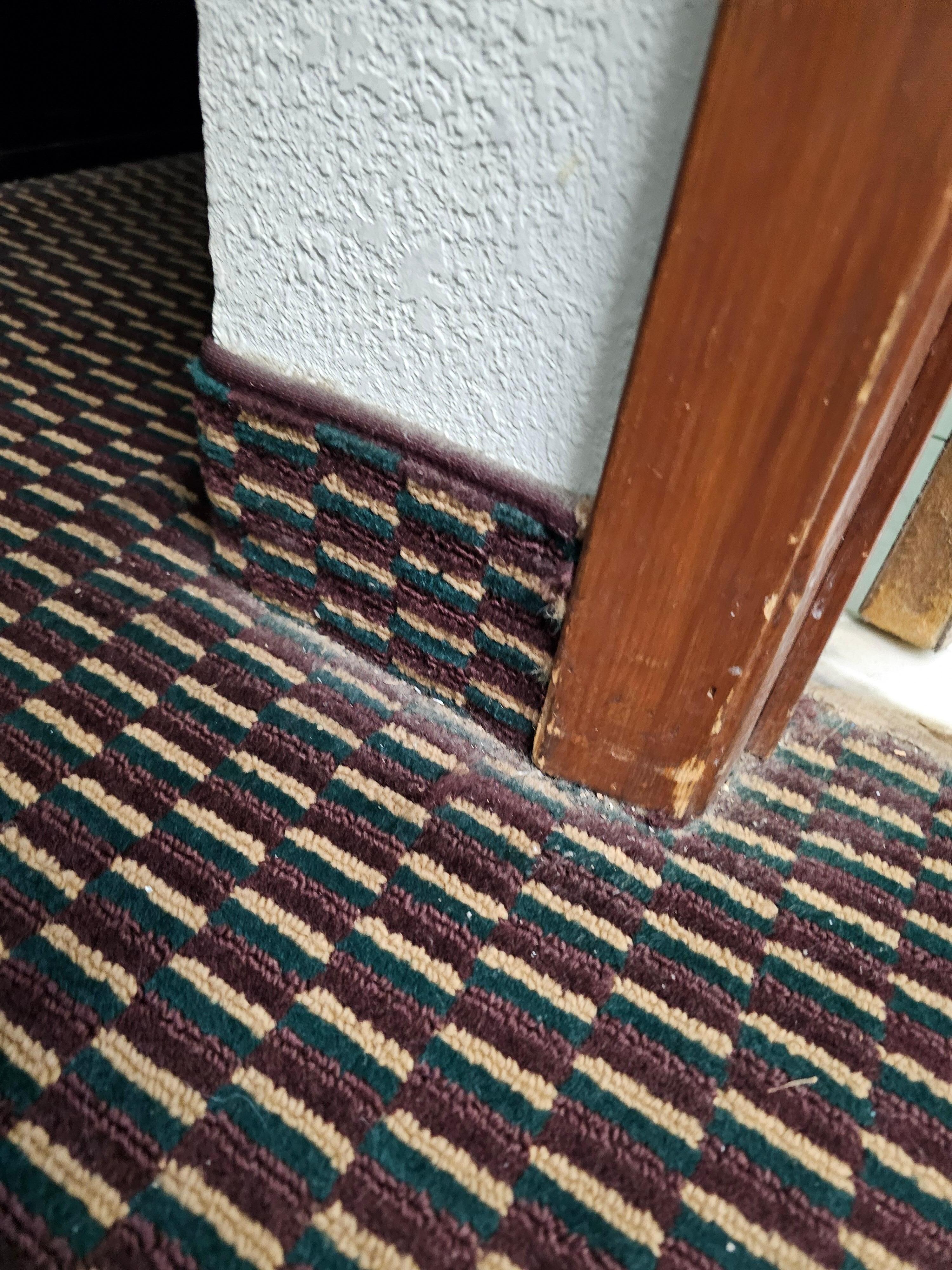 Piles of dirt along wall where vacuum don't get.