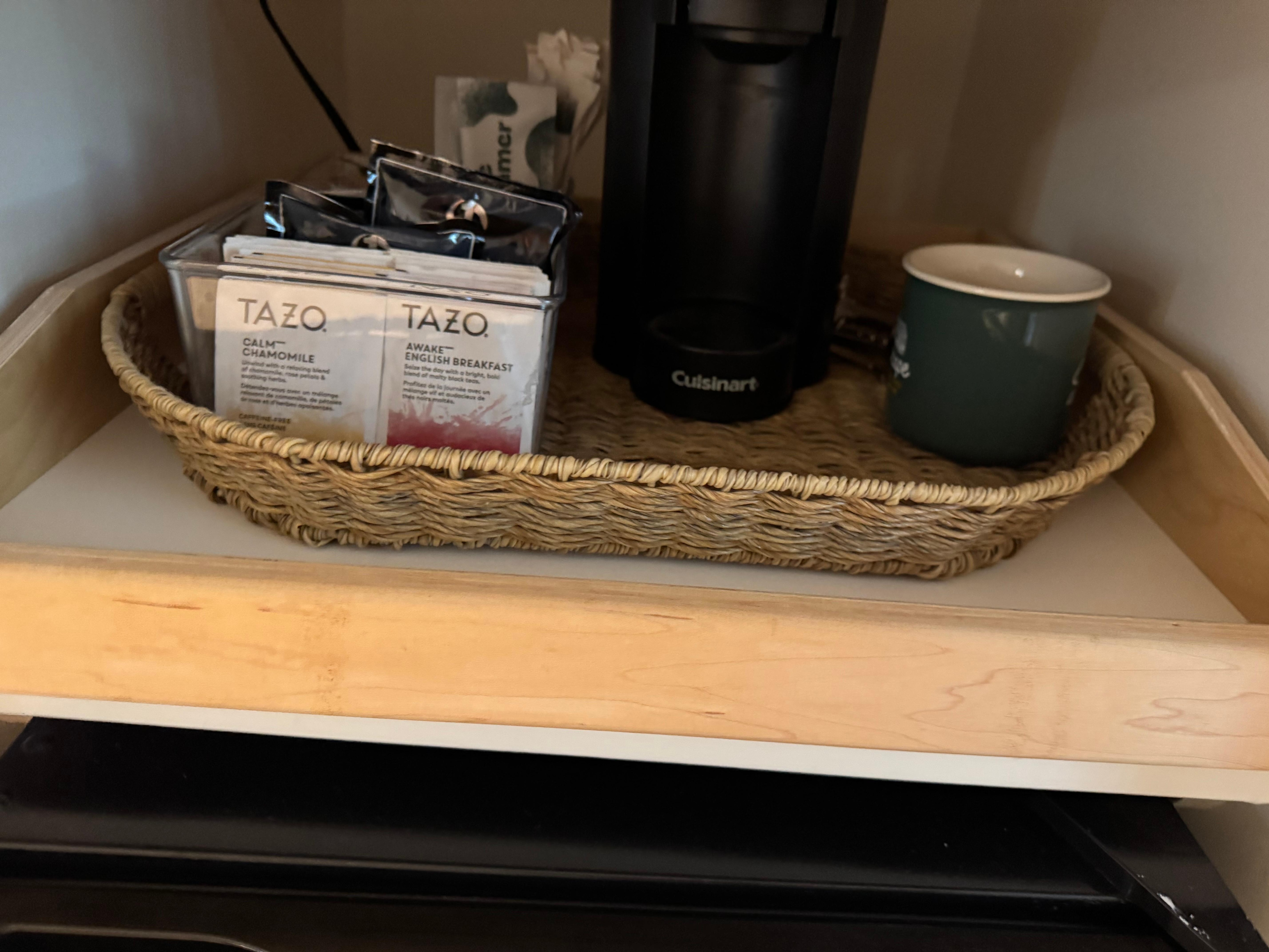 Cute coffee area by the tv and large refrigerator. 