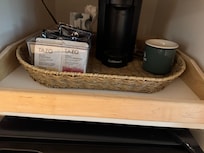 Cute coffee area by the tv and large refrigerator.