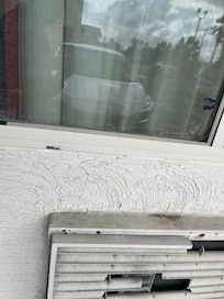 Mosquitero roto y parchado. La máquina del aire acondicionado muy deteriorada