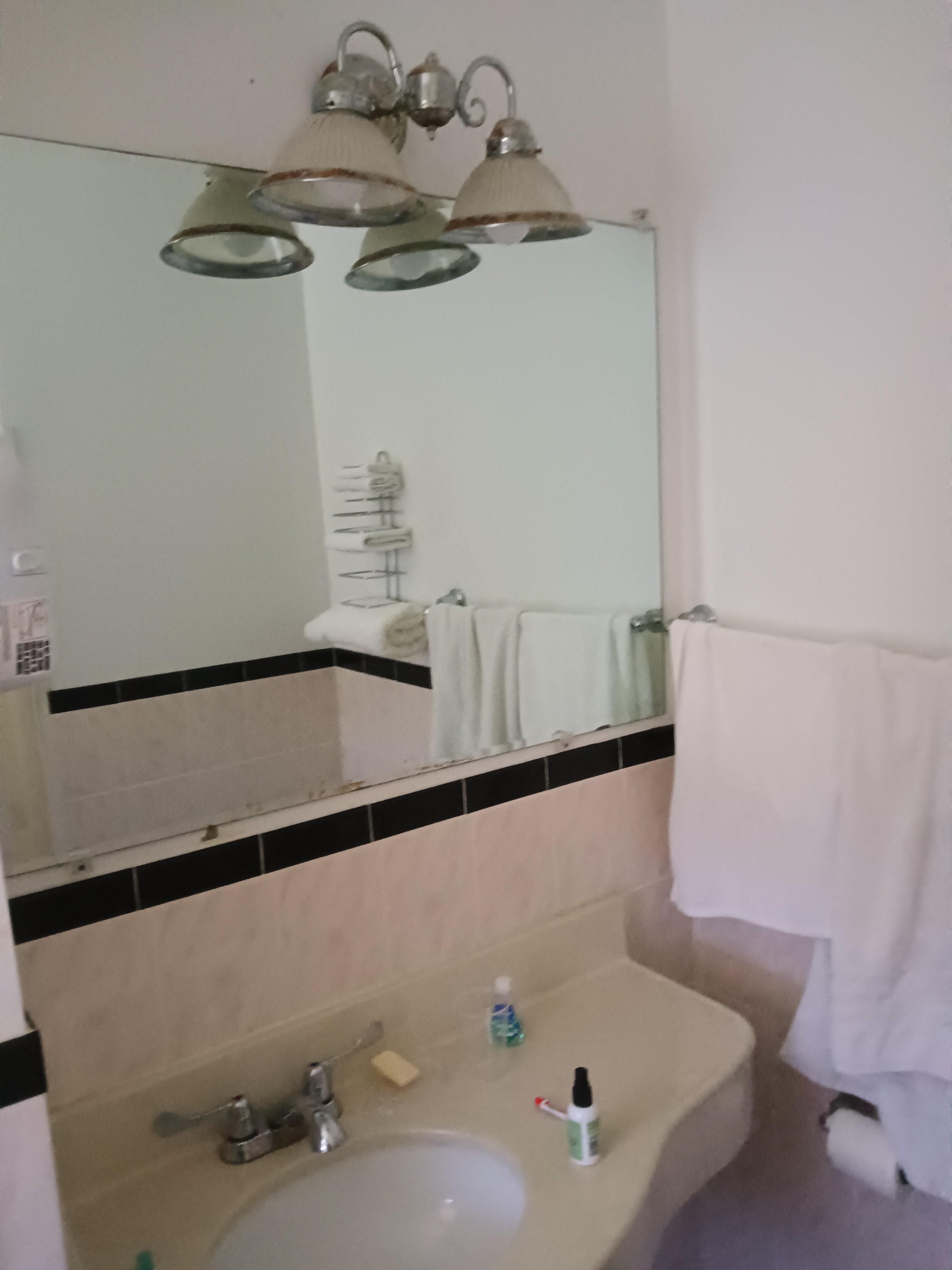 Bathroom was clean, but very outdated, with a rusted light fixture and rattling fan.
