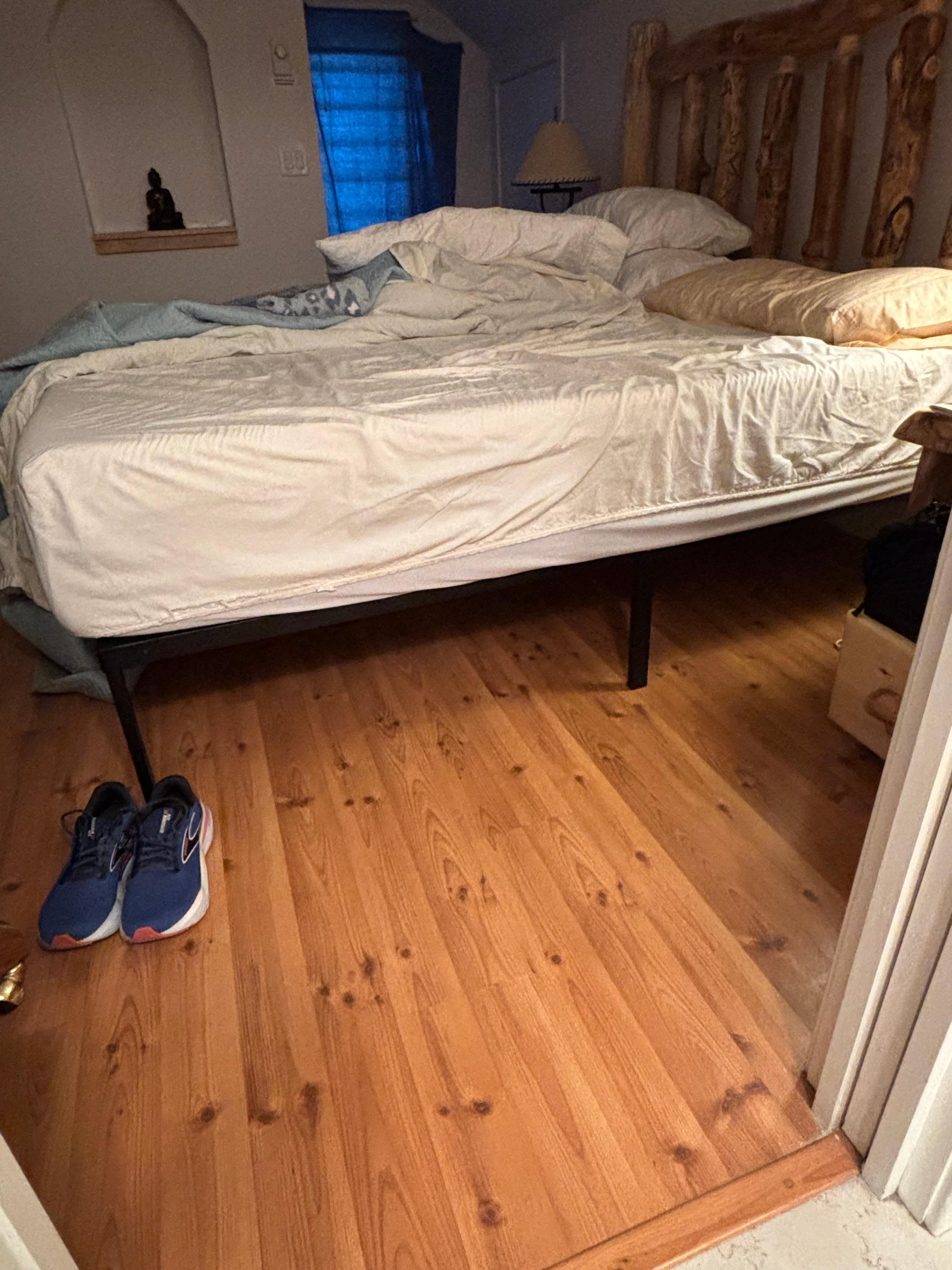 Hard metal bed frame running down lumber area length of bed