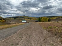 View from up the hill near a barn looking down to the cabins and common area.