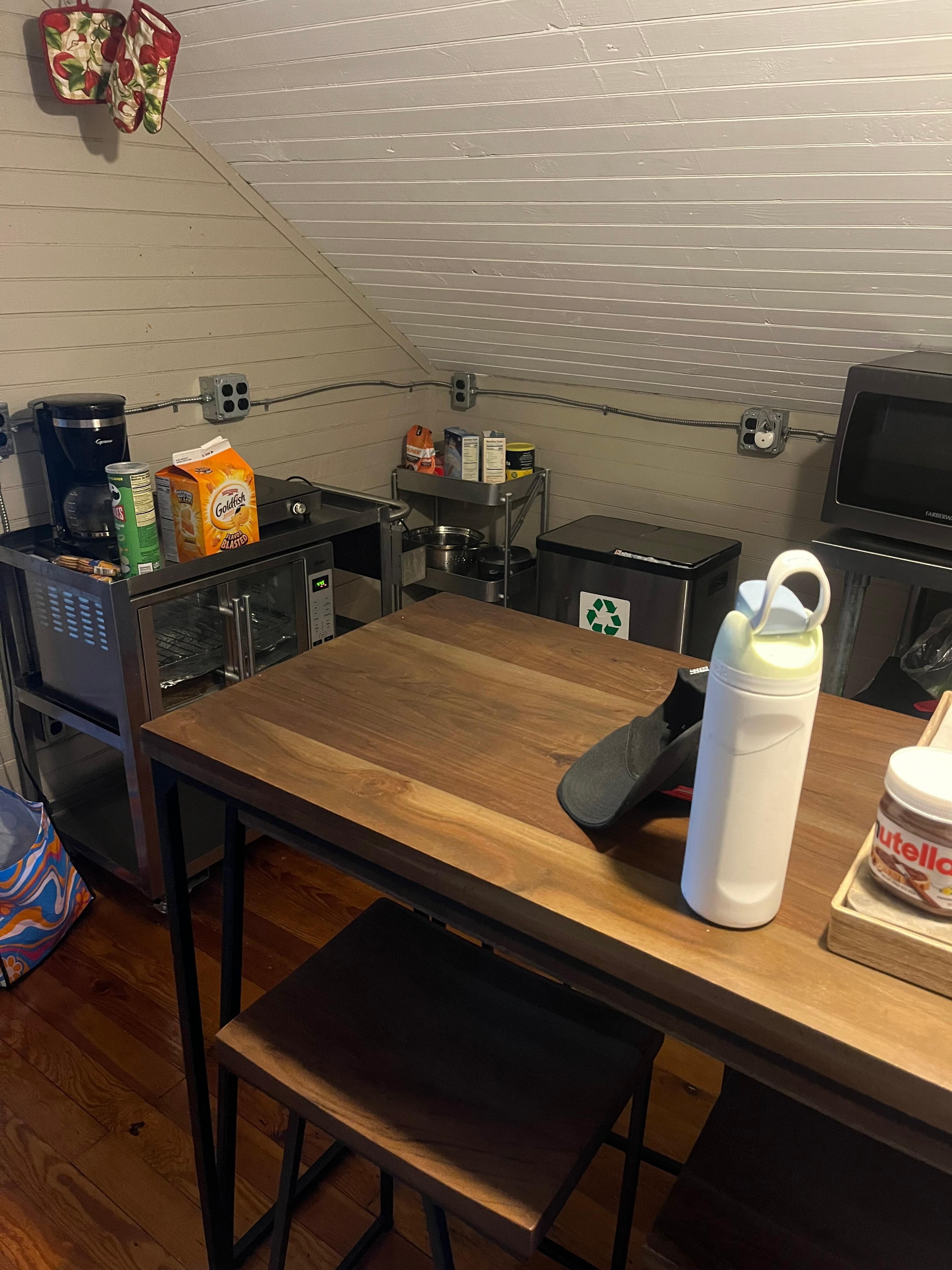 Small kitchen with a small beating area, microwave, toaster, oven, and coffee maker