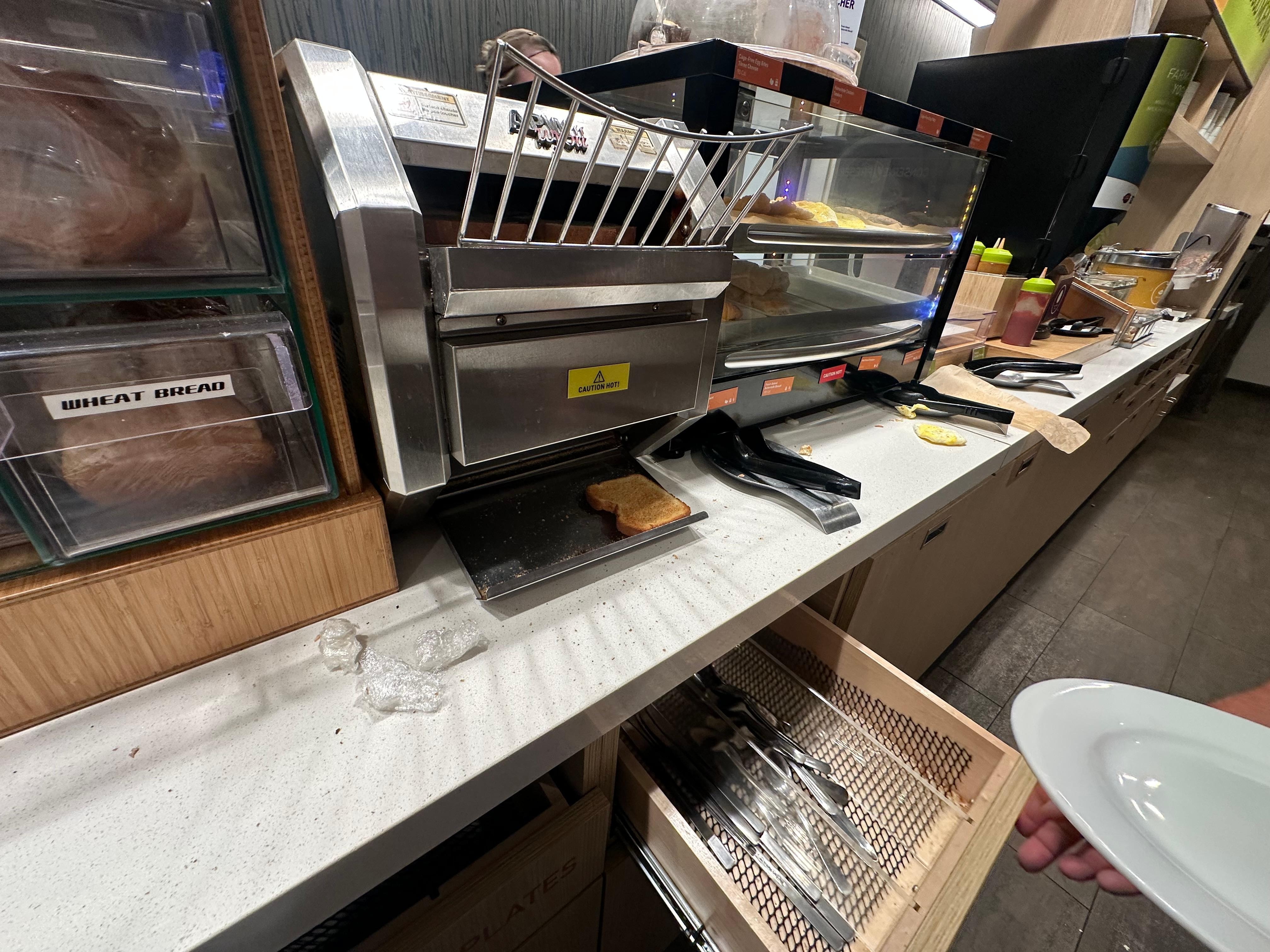 Open slide out below holds silverware, full of crumbs and food debris.