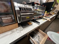 Open slide out below holds silverware, full of crumbs and food debris.