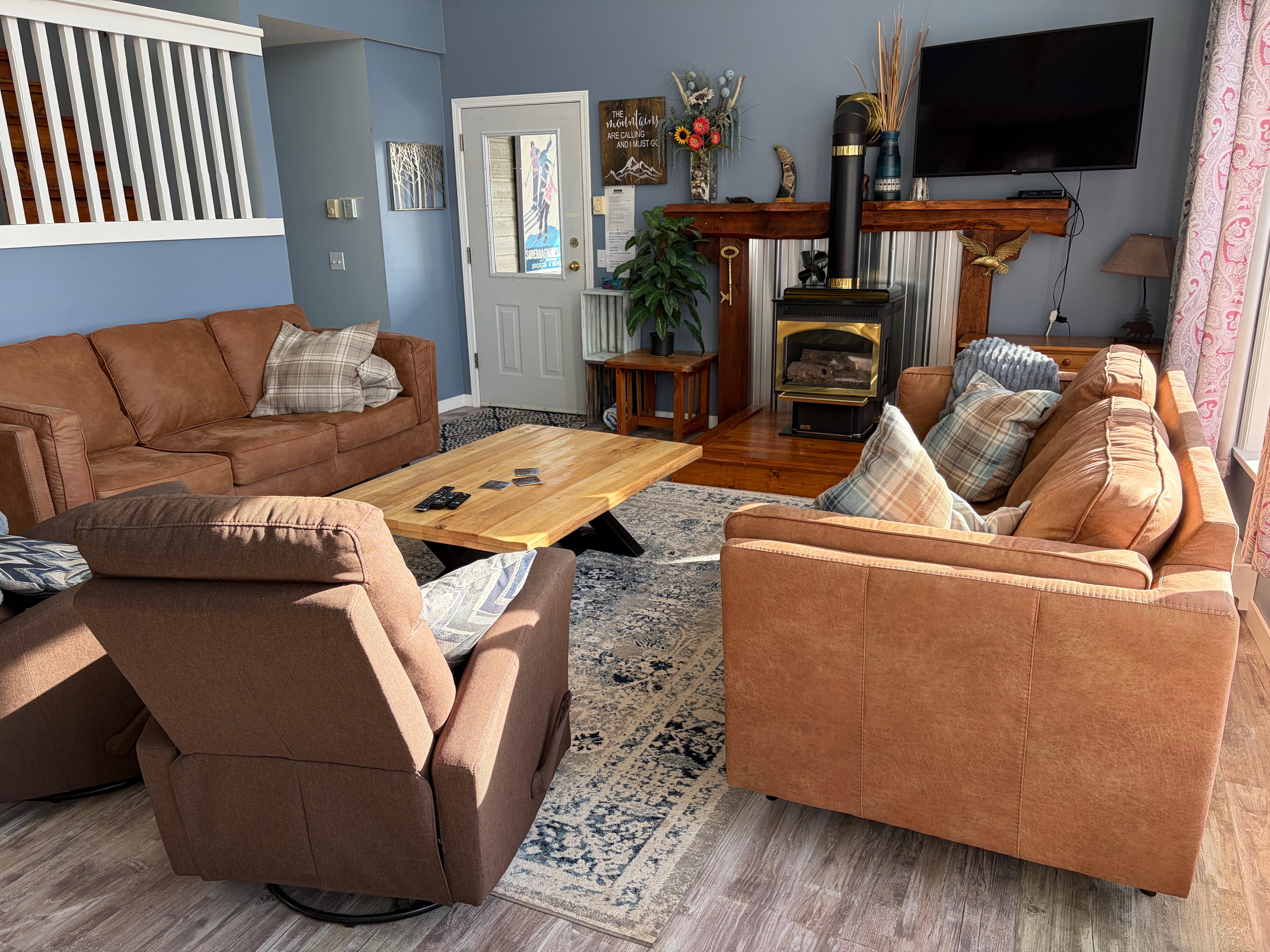 Living room, door to hot tub, and stairs to upper two bedrooms