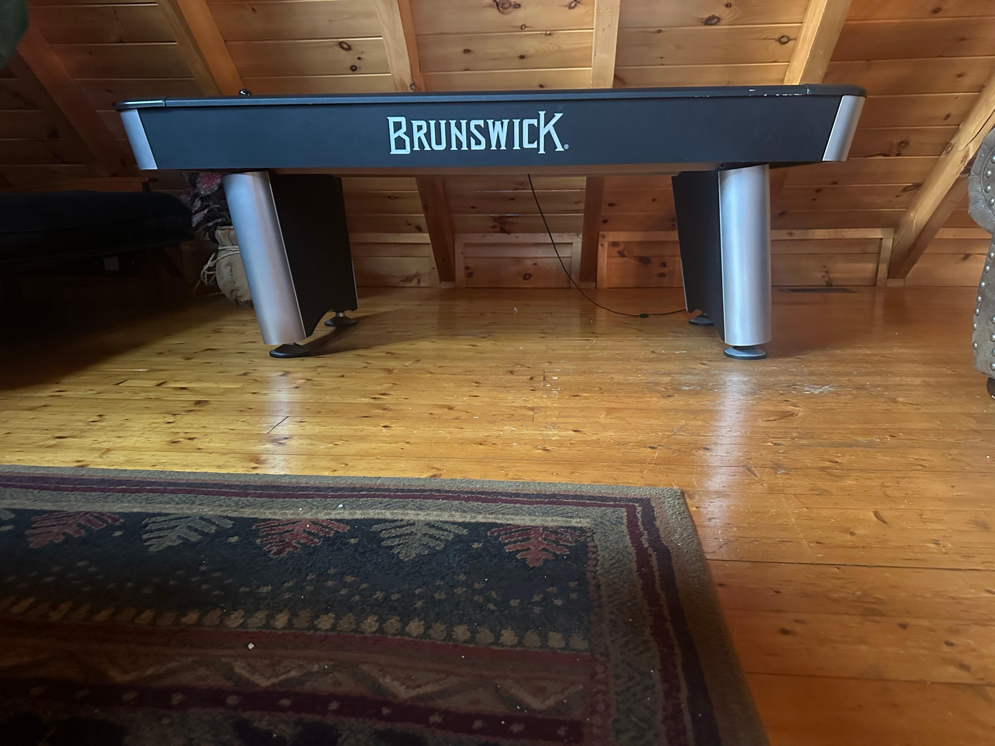 Air hockey table leaning over 