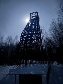 The image features the Plummer Mine Headframe, a historic iron mining structure located in Pence, Wisconsin.
Historic Landmark: Opened in 1904, it is the last remaining steel mine headframe in Wisconsin and is listed on the National Register of Hist
