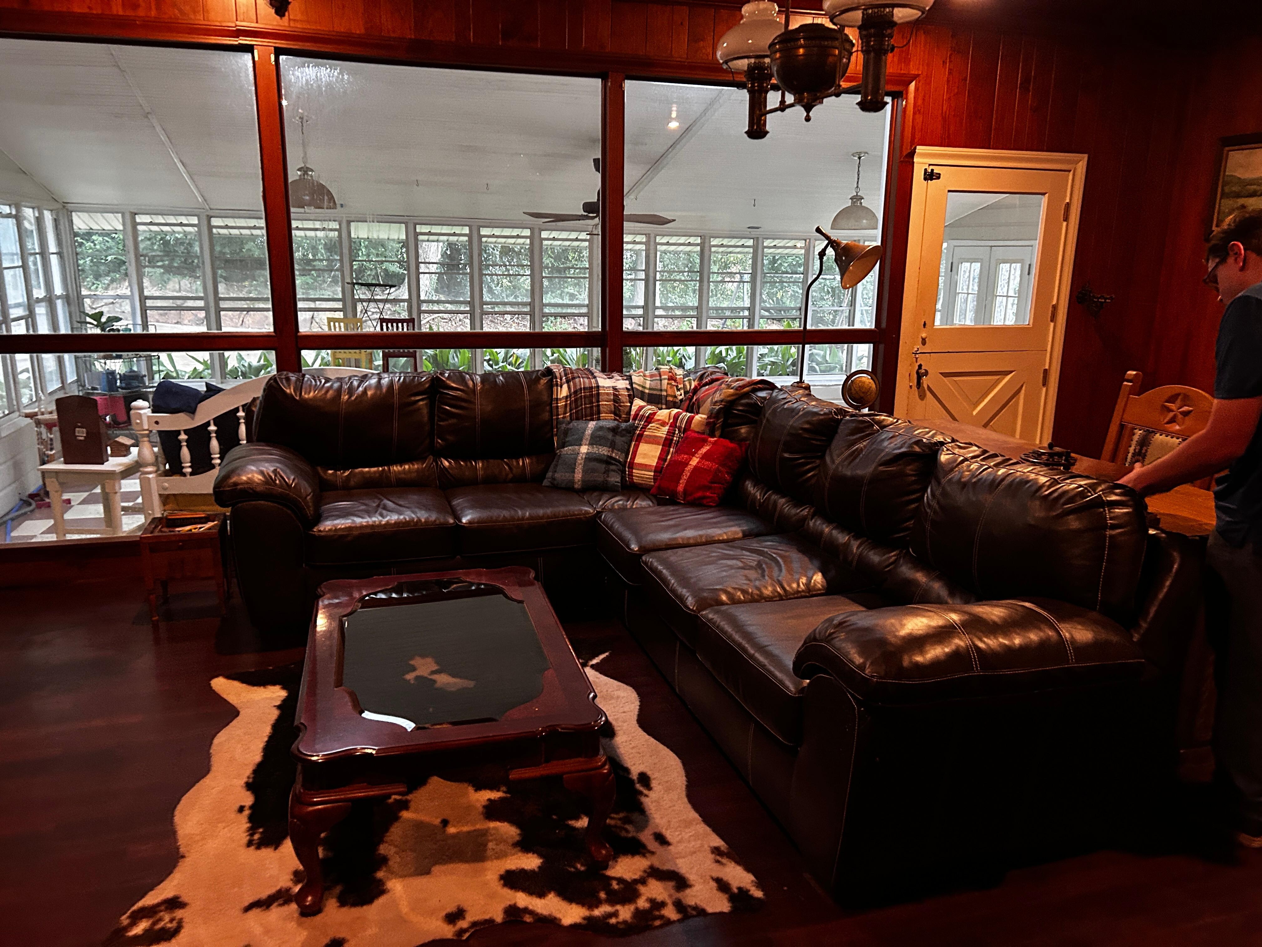 Super comfortable leather couch invites you to  read a book and take a nap or converse with family. 