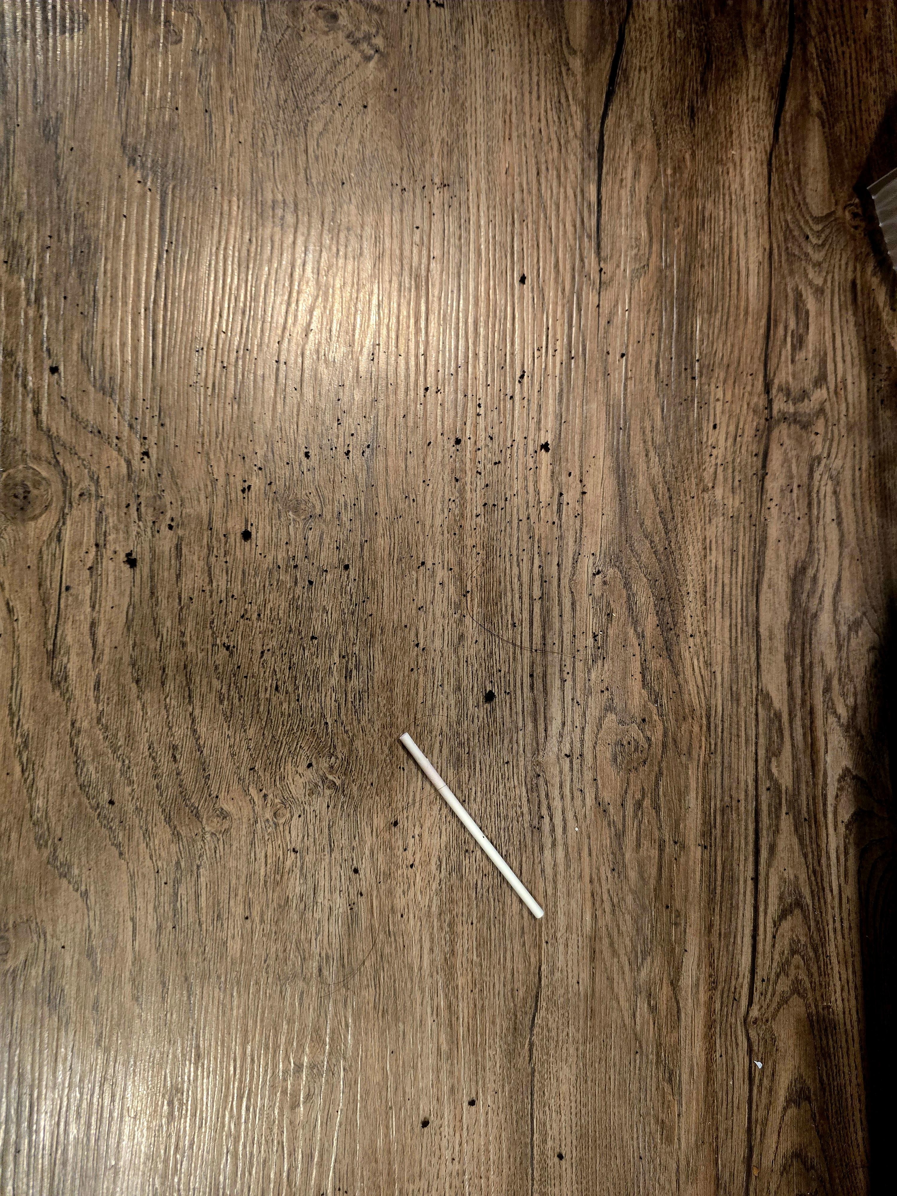 Coffee grinds and lollipop stick on floor