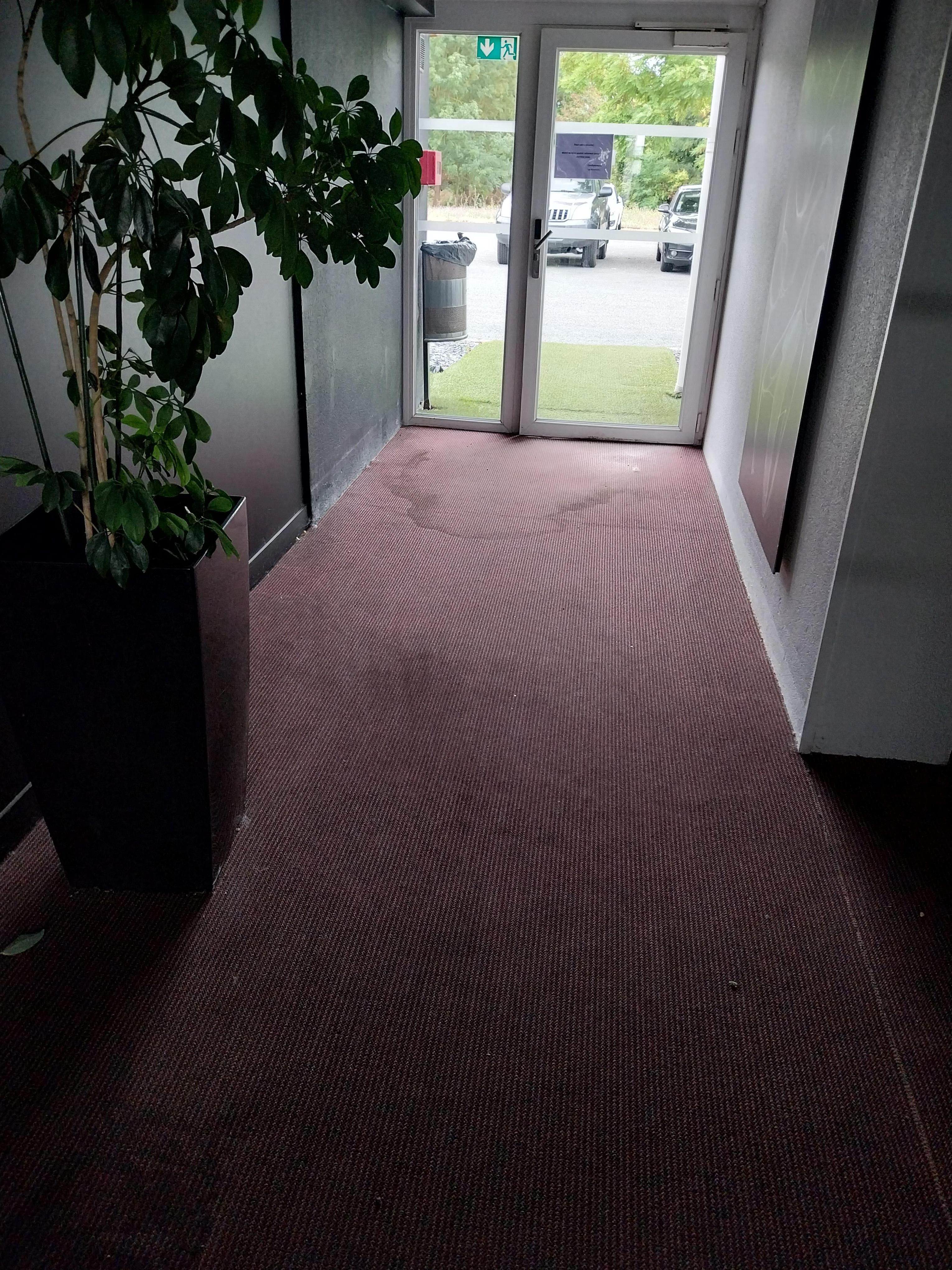 Entrée côté parking. Moquette tachée un peu partout.