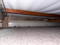 Trash, including a pacifier, under bed