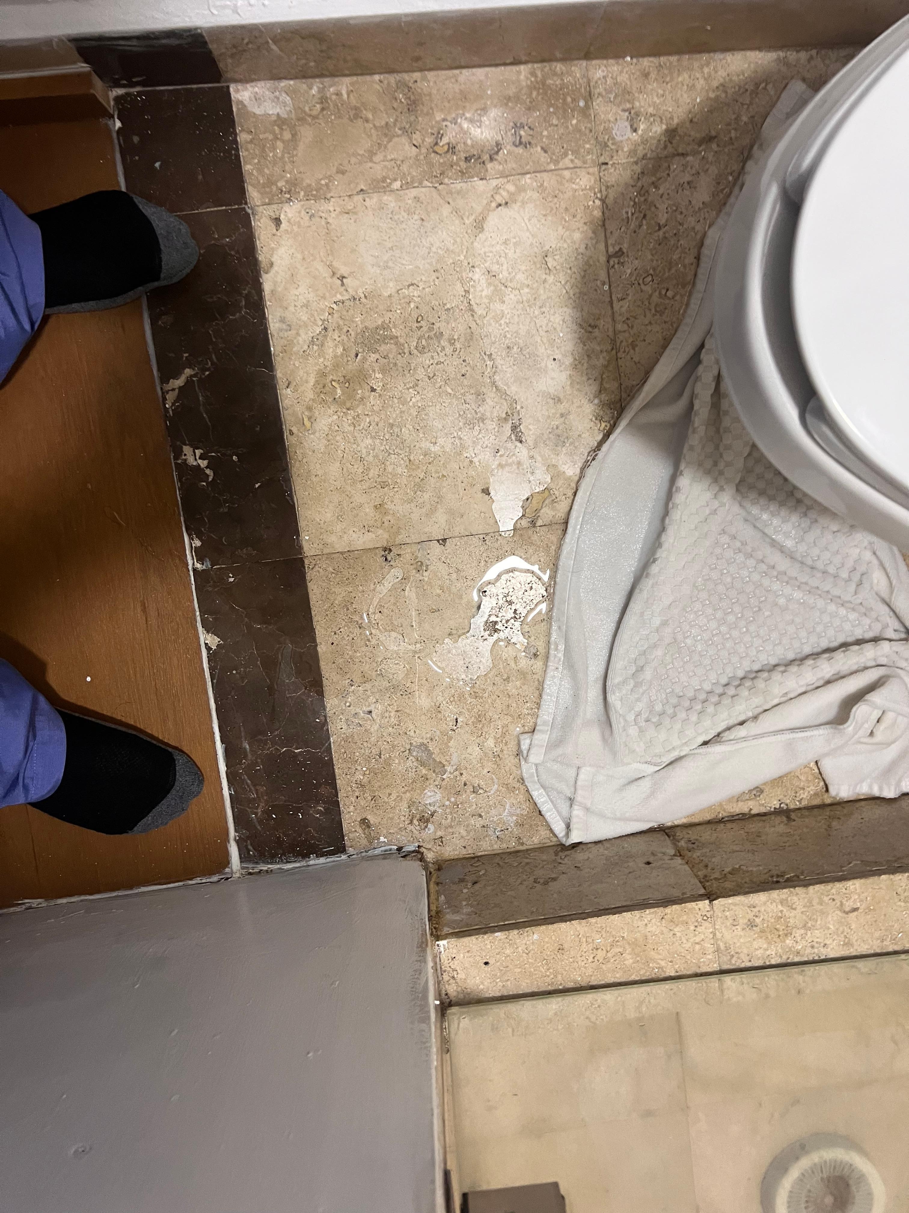 Wet floor and prior repair where tile used to be. 